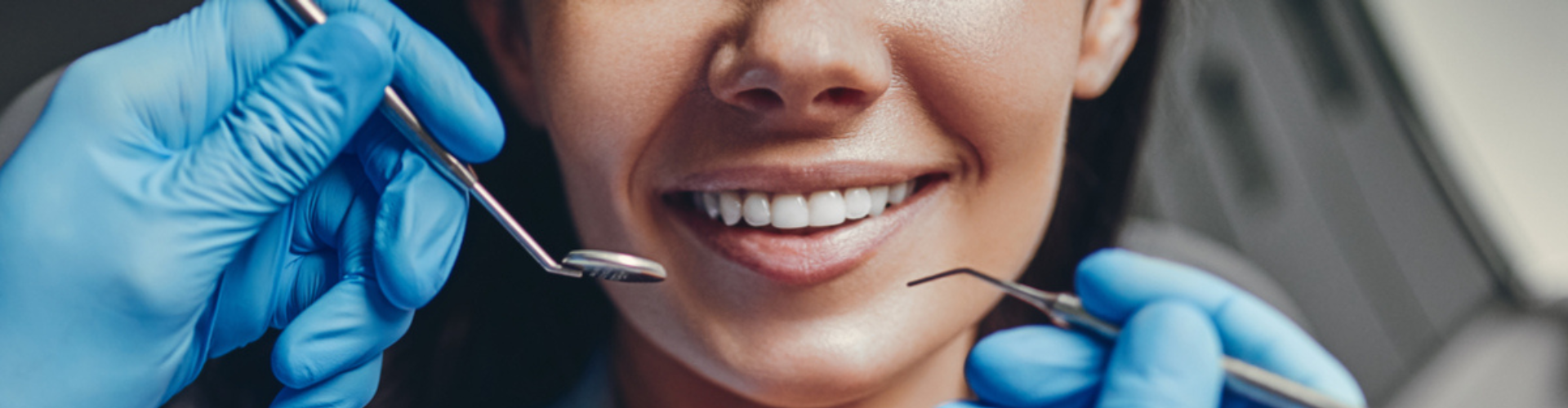 A patient smiling with dental tools arranged around them.